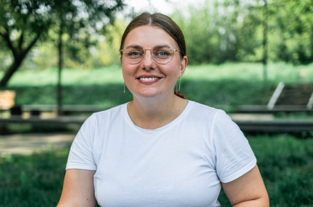 Kvinde med briller sidder på græsplæne