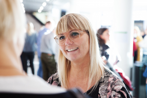 Kvinde snakker med person på konference