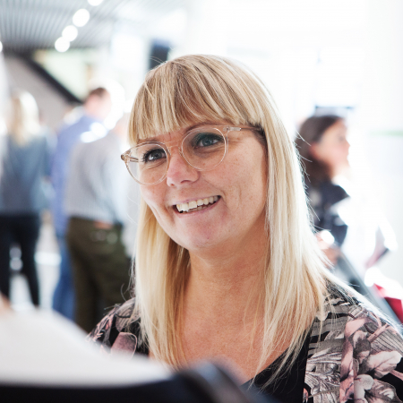 Kvinde snakker med person på konference